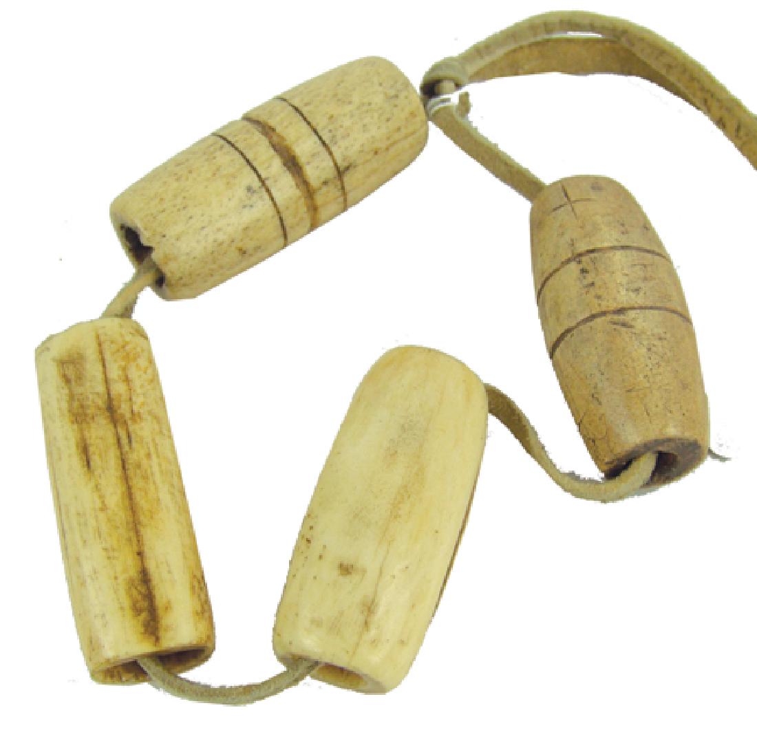 Blackfeet Stick Game Bones: Early/Mid 1900s, Wonderful old set of carved bone gaming "bones," two with the bands around them used for guessing/hiding during the game to gain the "sticks." Very good condition. A great set. Approx