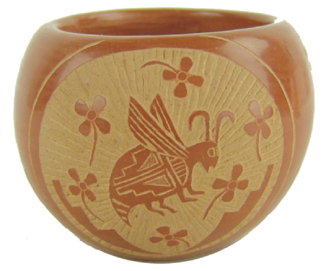 Santa Clara Pottery Bowl -Corn Moquino (1929-2015): Late 1900s, Beautiful redware sgraffitto bowl featuring a flying ant-type figure, flower, and geometrics. Very good condition. 3" x 4"