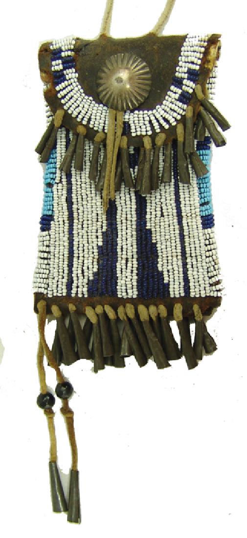 Kiowa Beaded Strike-A-Lite: Traditional flared latigo flat bag with lazy stitch beaded designs, tin cone suspensions, and a single silver concho on the front. Done in the old style, very good condition.,Mid/Late 1900s,5" plus fr