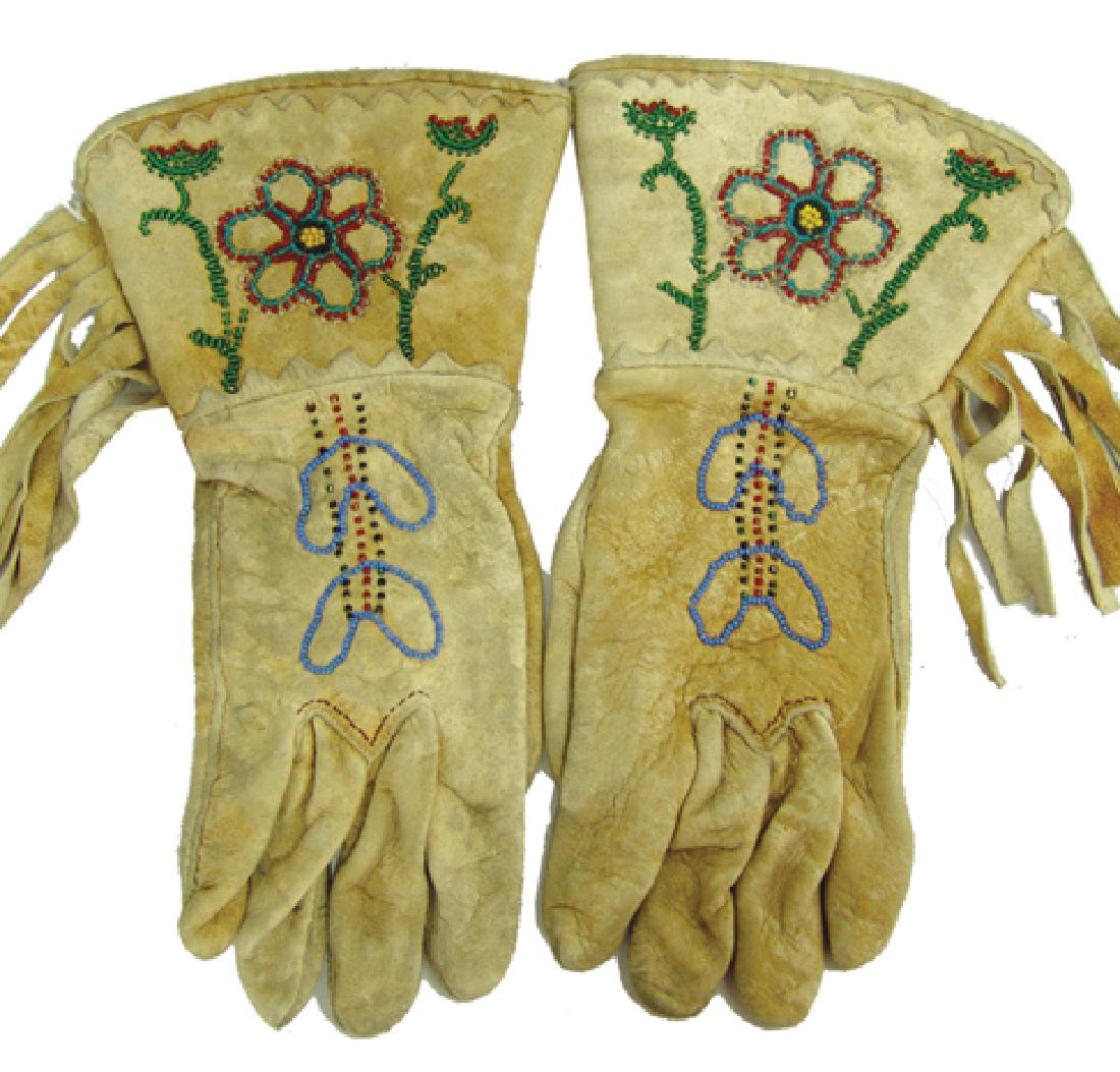 Chippewa/Cree Gloves: Traditional pair of hand and machine sewn all buckskin gloves with beaded floral accents, fringed sides, and scalloped trim. Very good condition.,Ca. 1930s-1940s,11"
