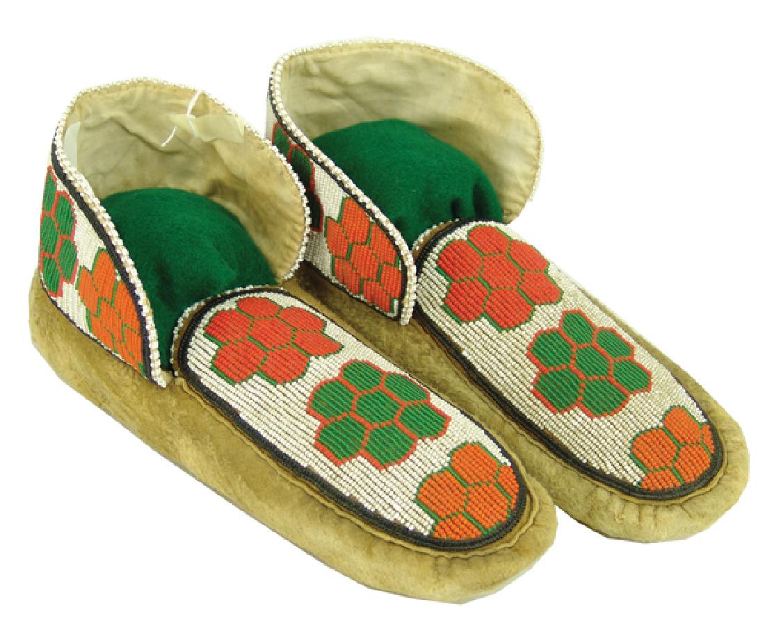 Cree Beaded Moccasins: Colorful pair of moose hide moccasins with fully beaded vamp and ankle panels with floral forms. Very good condition.,Mid 1900s,11"