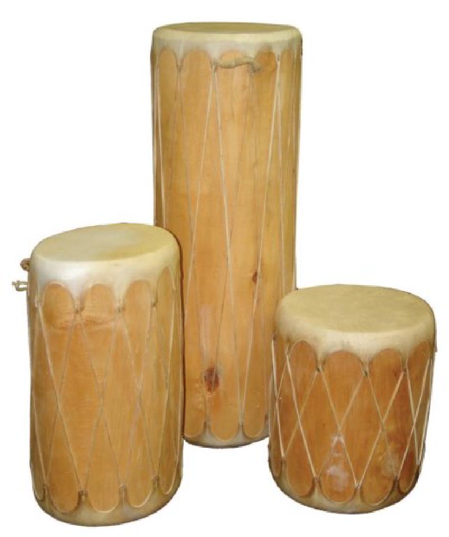 3 Taos Log Drums: Group of three expertly hand crafted drums made from hollowed logs and with stretched buckskin heads. All traditional pieces that make great decorative items. Very good condition.,Ca. 1980s-1990s,Larg
