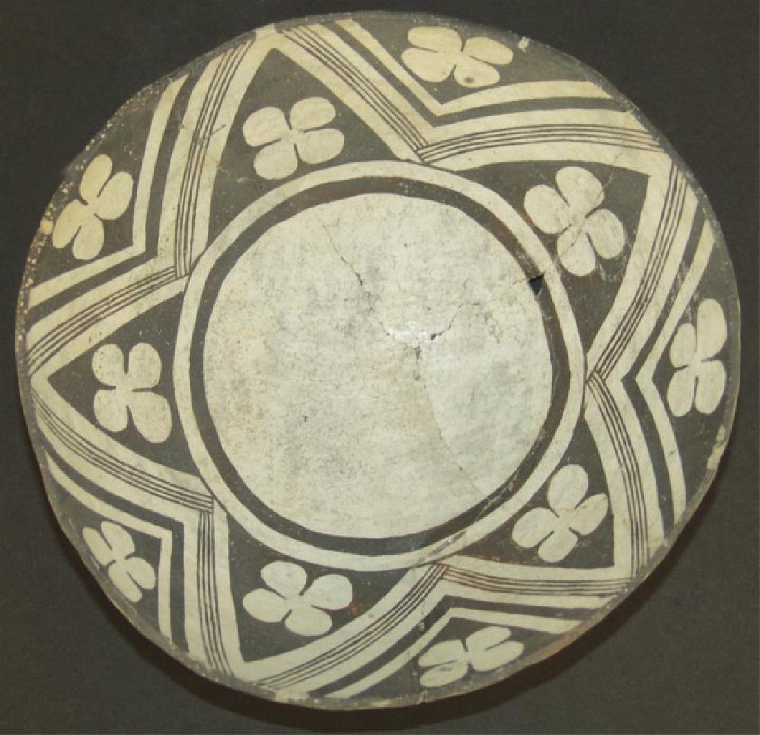 Mimbres Pottery Bowl: Pre-HistoricWonderful, flared black-on-white bowl with wide design band containing bold white zig-zags with hachured center bands, and with rare four leaf clover symbols within. Very good condition, a