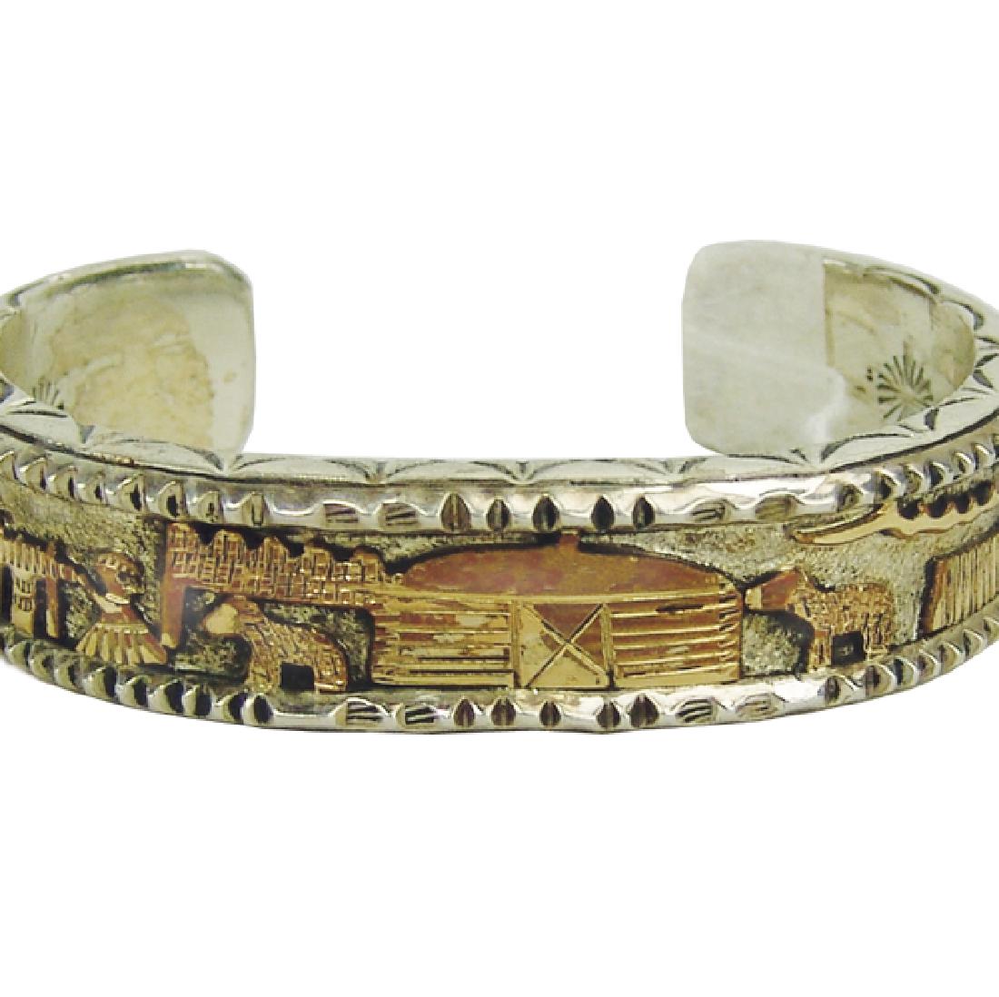 Navajo Silver and Gold Bracelet - Roger Nelson: Beautiful, heavy gauge, handwrought all silver bracelet with intricate stamp work inside and out, and with a 14kt gold Navajoland scene in the middle. Very good condition.5-1/2" + 1-1/4" x 5/8"Mid/Lat