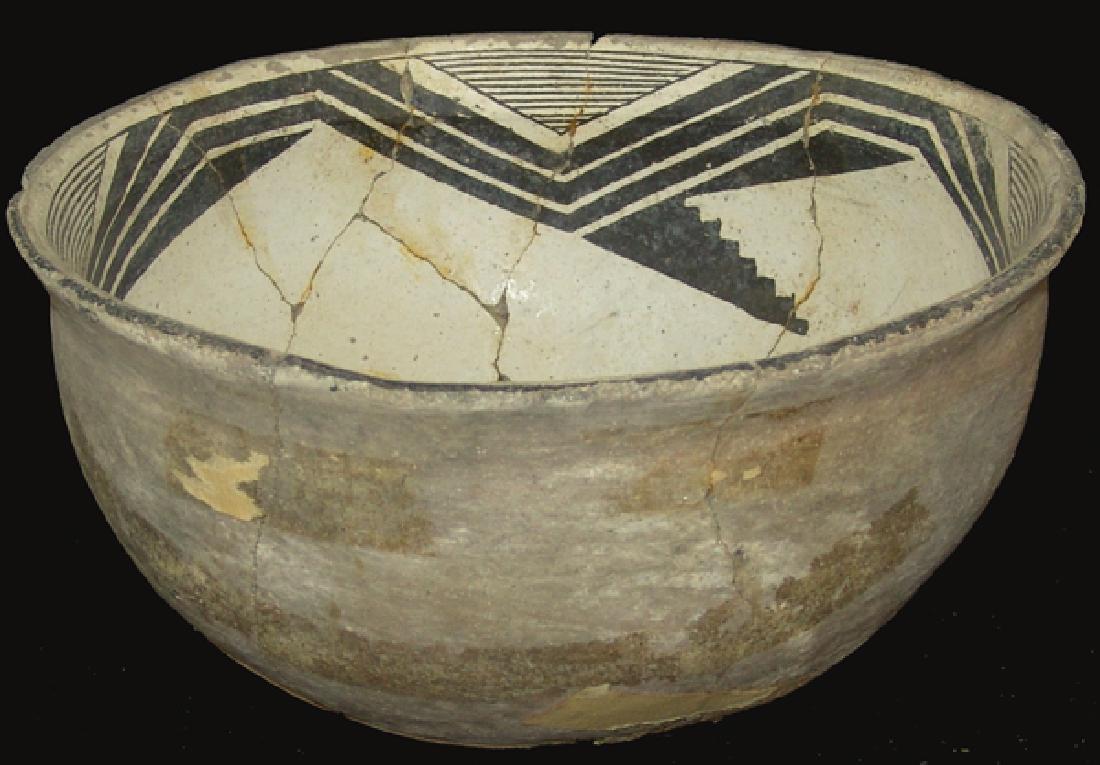Mimbres Pottery Bowl: Deep, killed, black-on-white bowl with flared rim having four triangle pendants of fine line and wide line design, each having a stepped solid right triangle attached. Good condition, repaired/unresto