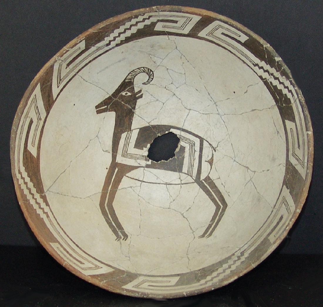 Mimbres Pottery Bowl: Fantastic, killed, black-on-white bowl with rim band having stepped and geometric wide line pattern, the center containing a rare ram figure with similar design body. Very good condition, minor profes