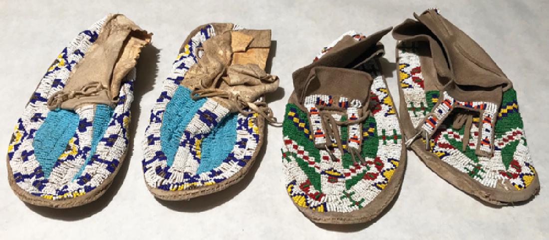 Plains Beaded Moccasins: Two pair of sinew sewn and lazy stitch beaded buckskin moccasins with rawhide soles and traditional designs, one with bifurcated tongues. Poor condition, some holes, etc.AdultEarly 1900s