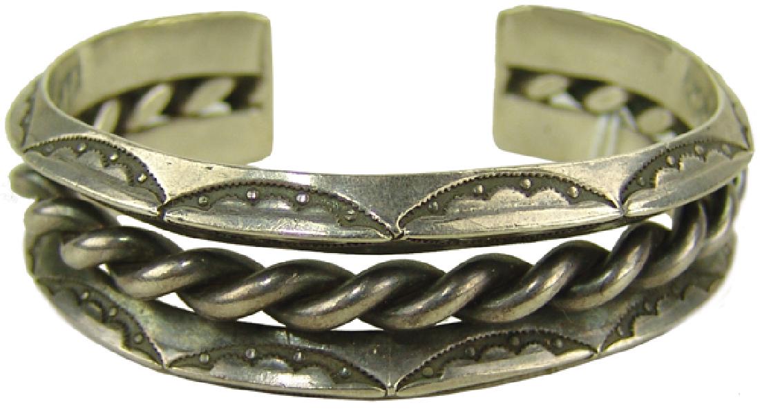 Navajo Bracelet: Vintage, three-band, coin silver cuff bracelet with stamped crescent details on the outer bands. Very good condition. Stamped "IH-Coin Silver."5" + 1" x 3/4"Mid 1900s