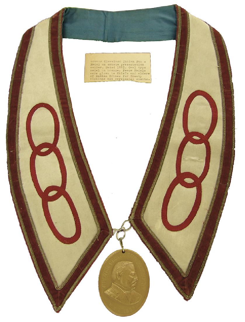 Bronze Peace Medal Display: Various Ages Labeled display showing an early 1900s silk and ribbon presentation collar holding a U.S. Mint issued solid brass, Grover Cleveland peace medal from the mid to late 1900s. Very good condi