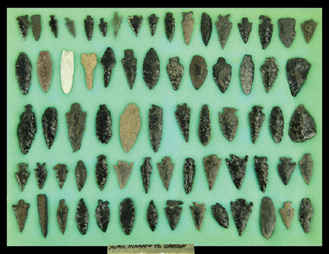 Oregon Obsidian Display: Collection of 70 excavated obsidian arrowheads, scrapers, and tools marked "70 pcs Klamath collection Oregon." Various conditions, in 17" x 12" ryker mount.Largest 2-1/8"Pre Historic