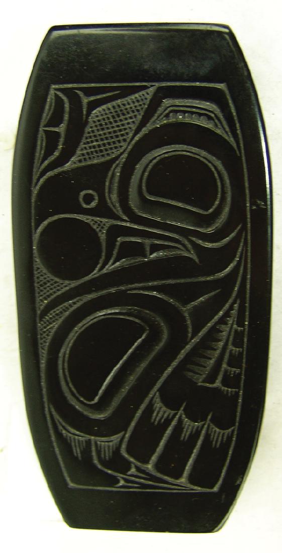 Haida Algilite Carving - Pat McGuire (d. 1970): Heavy, hand carved, solid argillite dish with "Haida Raven and Sun" design. Signed on bottom. Very good condition.5-1/2" x 2-3/4" x 3/4"Mid 1900s