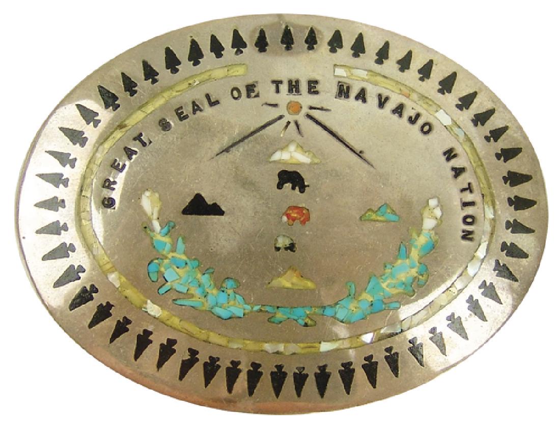 Navajo Belt Buckle: Wonderful, all silver oval buckle with inlaid and chip inlay features and "Great Seal of the Navajo Nation." Very good, used condition, unsigned.2-1/2" x 3-1/4"Ca. 1980s