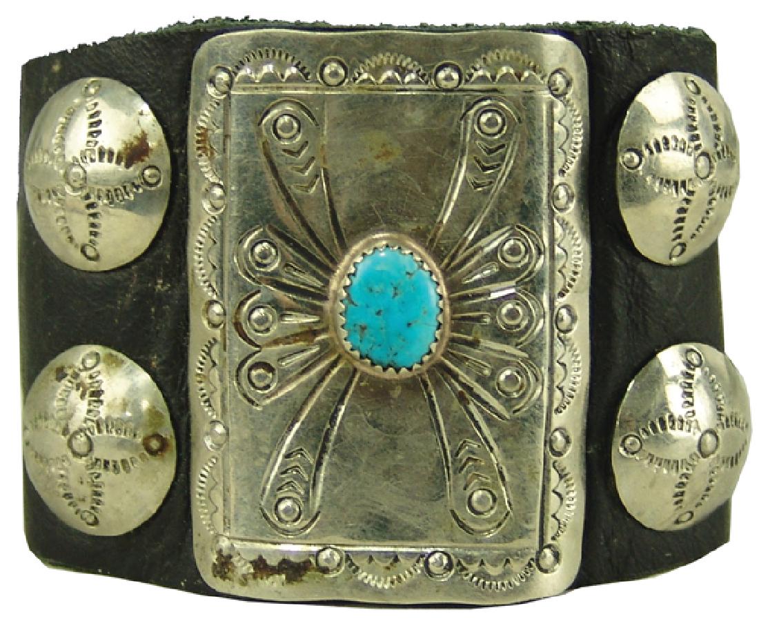 Navajo Child's Ketoh: Rare, smaller sized, handwrought all silver bow guard with single turquoise stone and four concho style buttons. Very good condition, unsigned.Ca. 1960s-1970s2" x 1-1/2"