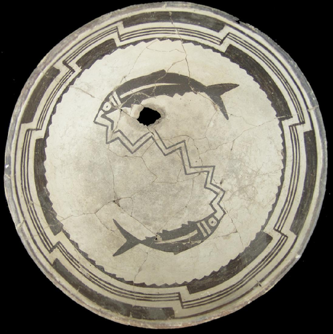 Mimbres Pottery Bowl: Deep, killed, black-on-white bowl with stepped rim band above the main design, a pair of opposed fish connected at the mouth with a zigzag line. Very good condition, glued, some professional restorati