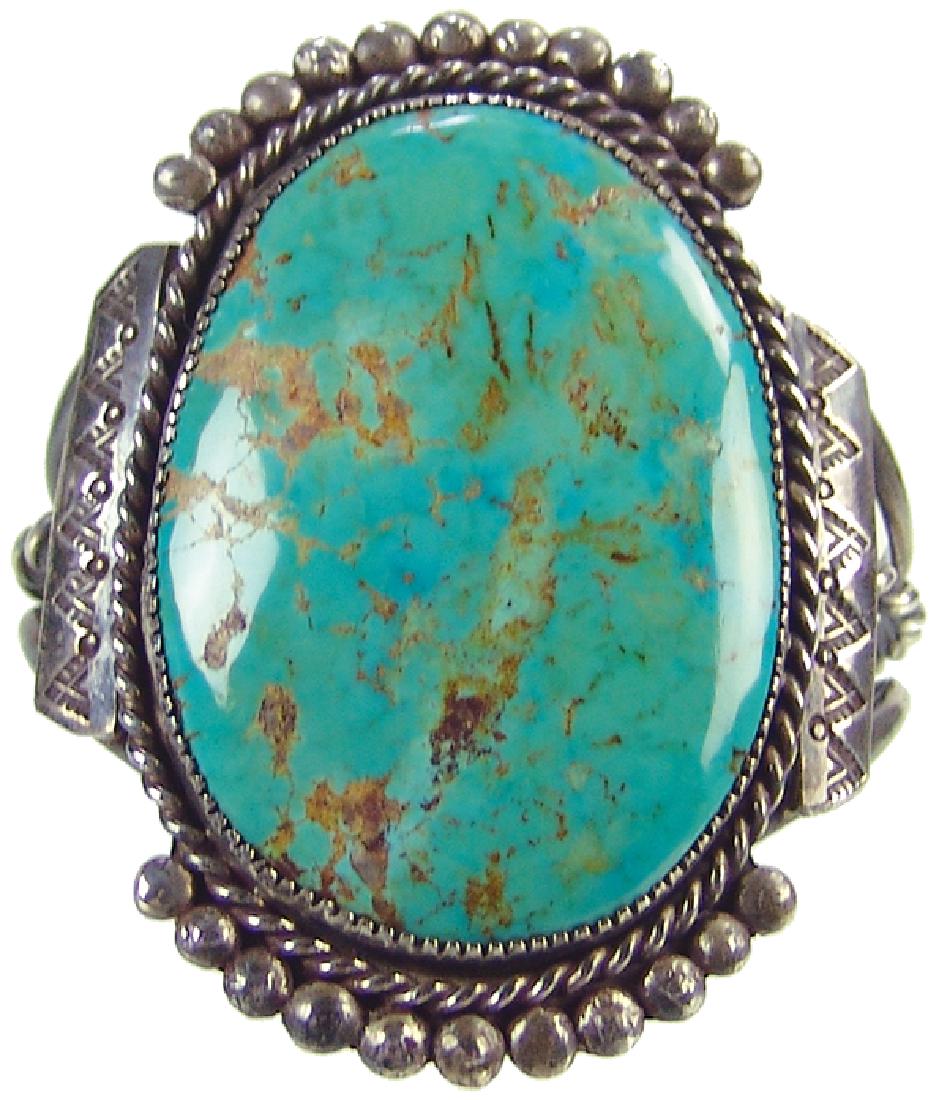 Navajo Bracelet - Leo Coriz: Impressive, handwrought all silver bracelet with classic stamp, file, and rope work details and with a huge, polished Cerrillos turquoise stone. Very good condition.Ca. 1980s 6-1/4" + 1" gap, with 4" 