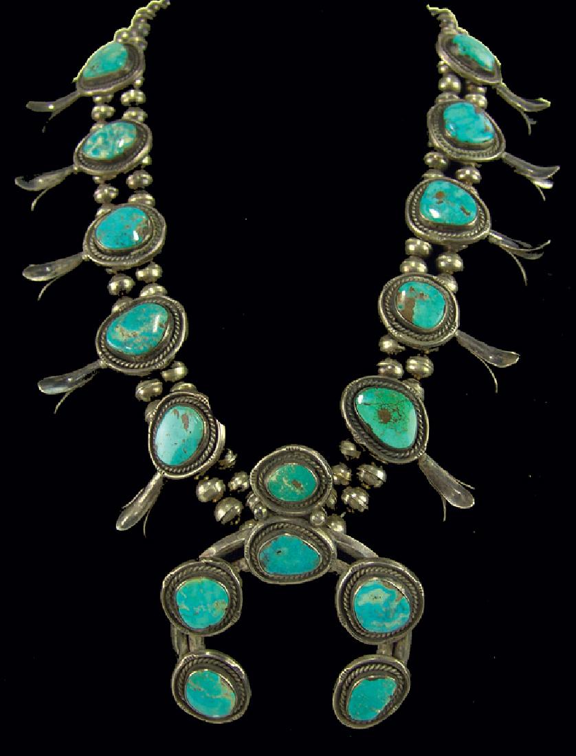 Navajo Necklace: Classic design turquoise and silver squash blossom necklace with 3" naja and 11, naturally aged turquoise stones. Very good condition.Ca. 1970s