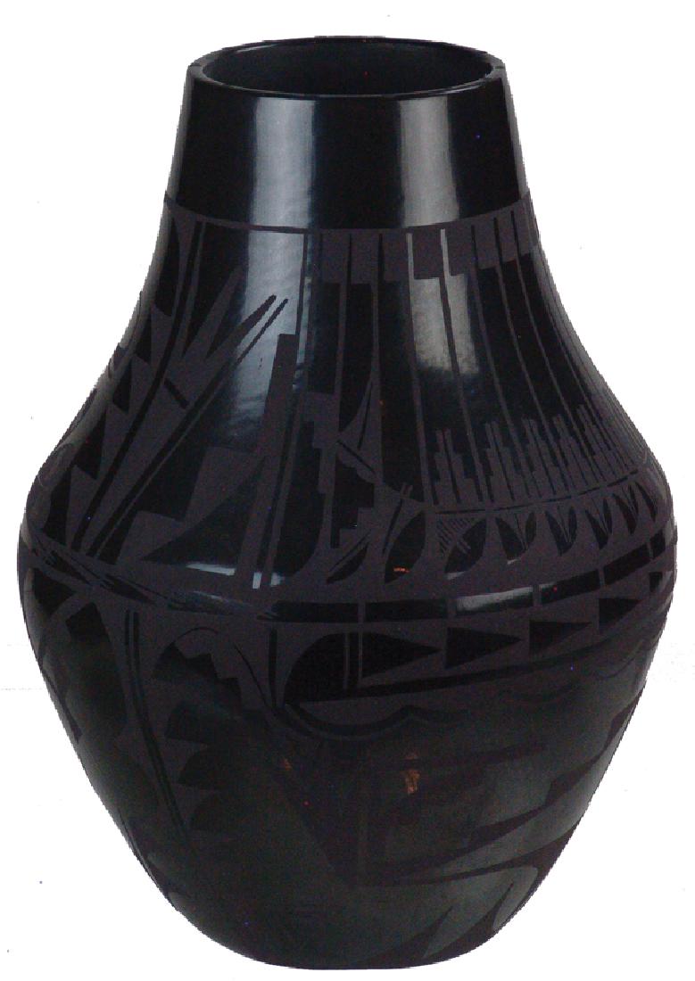 Carmelita Dunlap Pottery Jar (1925-2000): Large, fantastic, San Ildefonso black-on-black pottery jar decorated with elaborate floral ad avian motifs. Very good condition, a museum quality example.Ca.1960s16" x 12"