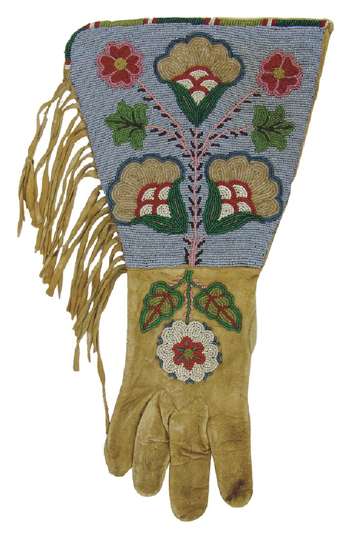 Plateau Beaded Gauntlet: Exceptional, single buckskin parade gauntlet with elaborate floral beading on the backhand and extended cuff, and with edge fringe. Very good condition. Wish we had both of them!Ca. 1930s17"
