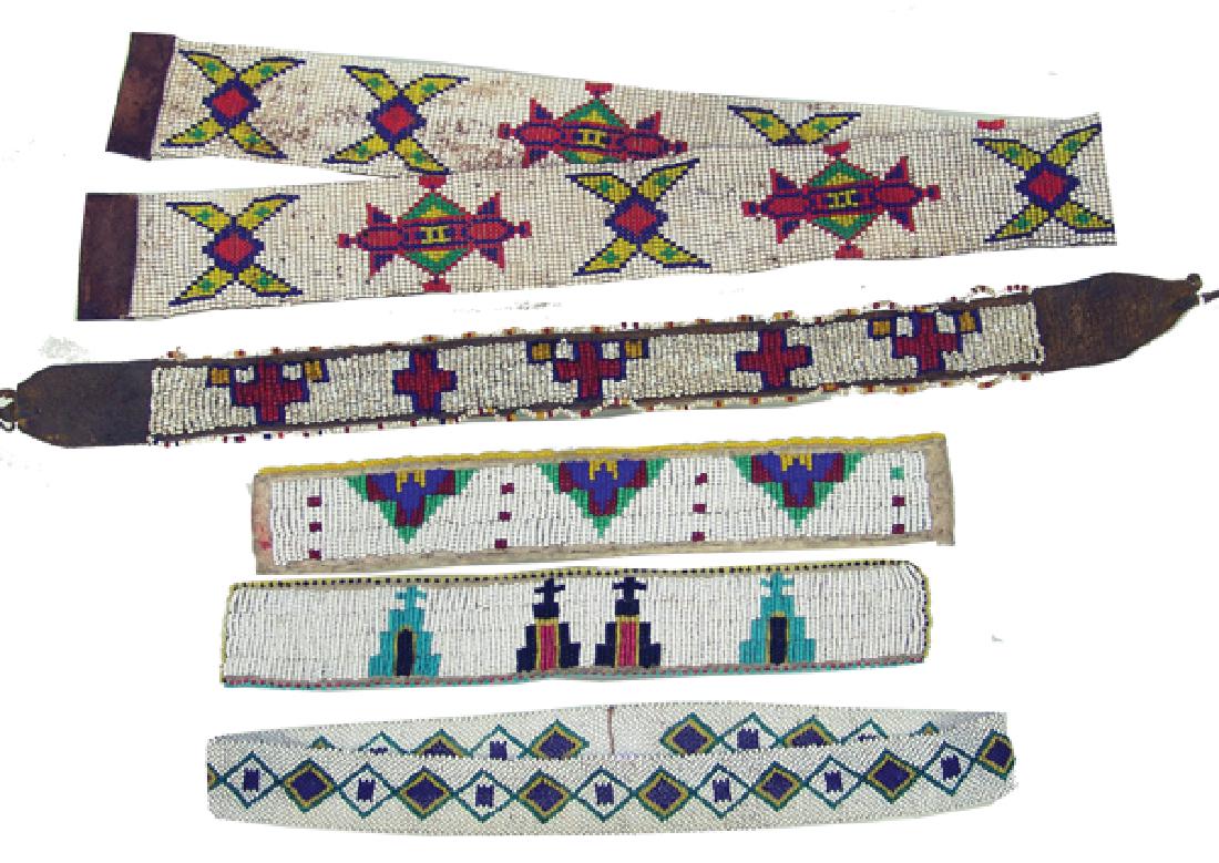 5 Beaded Strips: All vintage pieces including a 31" loom beaded belt, older loomed hat band, hat band with crosses, and two, lazy stitch beaded arm bands on buckskin. Good/very good condition.Ca. 1940s-1970sLargest 31