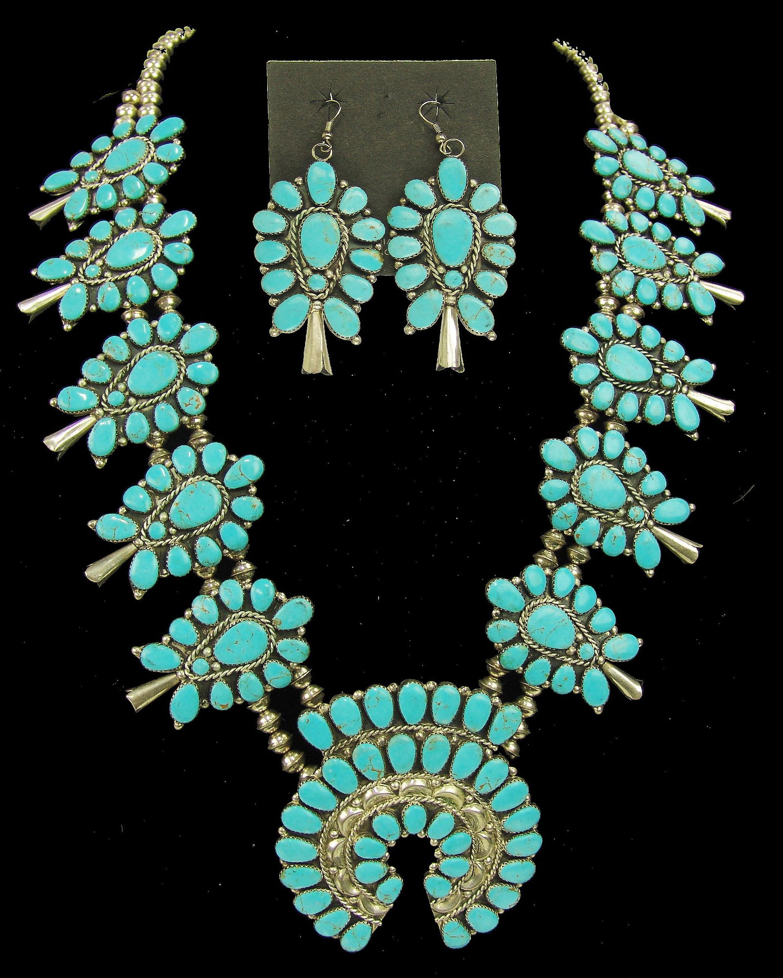 Navajo Necklace Set - Tom Billy: Ca. 1980s 28"Large and impressive, traditional, all silver squashblossom necklace done in cluster style, with a total of 249, individually hand cut and set turquoise tones, in the squash and matching