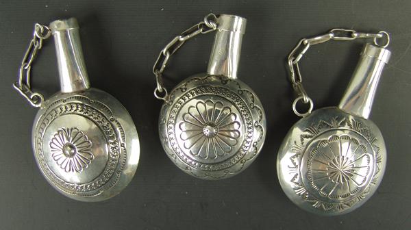 3 Navajo Silver Canteens: Ca. 1980s Largest 3" x 2" Group of same maker, hand wrought miniature canteens with stamped, radiating designs both sides, and unique tapered necks holding the removable caps. Very good condition, uns