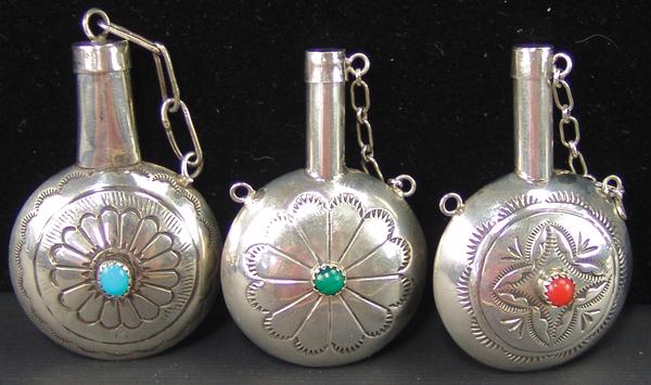 3 Navajo Silver Canteens: Ca. 1980s Largest 2" x 1-1/2" Group of three, all silver, hand wrought miniature canteens with stamped designs and a single stone on each side. Turquoise, coral, and malachite. Very good condition, un