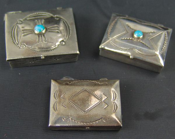 3 Navajo Pill Boxes: Ca. 1970s Largest 1-1/4" x 1-1/2" Collection of handcrafted, all silver boxes all with hinged lids and hand stamped designs, two also with single turquoise stones. Very good condition, unsigned.
