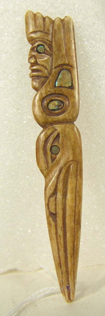 Northwest Coast Bone Amulet: Very finely carved totemic icon with inlaid abalone eyes and details on the raven and human figures by Rich Lavalle, unsigned. Condition: Excellent. Circa 1970s. 4" x 3/4" x 1/8"