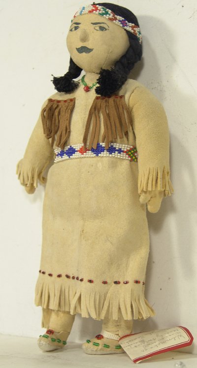 Winnebago Beaded Doll: Mildred Bearskin. Unique handcrafted buckskin doll with beaded accents, inked facial features, moccasins, and thread hair. Maker was only 15 years old at the time. Condition: Very good. 1980. 11-1/2"