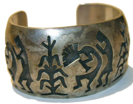 Hopi Bracelet: Outstanding Old Pawn sterling overlay cuff-style bracelet with hunchback flute player and corn motif. 6-1/2" plus 1-1/4" gap x 1-1/2" wide Circa 1980