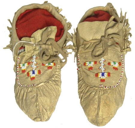 Cree Moccasins: Pair of traditional puckered toe buckskin moccasins with fringed ankles and beaded designs; very good condition. 9-1/2" Ca. 1950s
