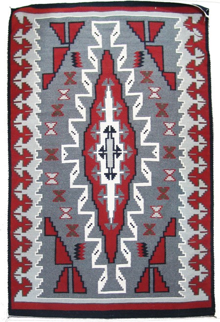 Navajo Rug - Mary Tapaha: Very tightly woven home spun Klagetoh with red, black, and white central lozenge on gray ground. Includes photo of weaver. 7'7" x 5'3" Circa: 1980