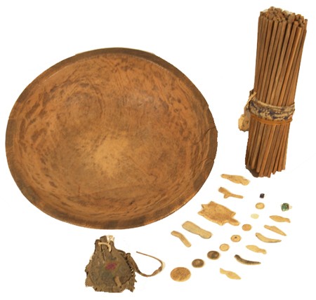 Chippewa Game Set: Very rare set consisting of a wooden bowl, carved bone and ivory objects (humans, turtle, ducks, birds, rifle, horse, spear, round discs, etc.), approximately 80 sticks of the same size, and a buckski