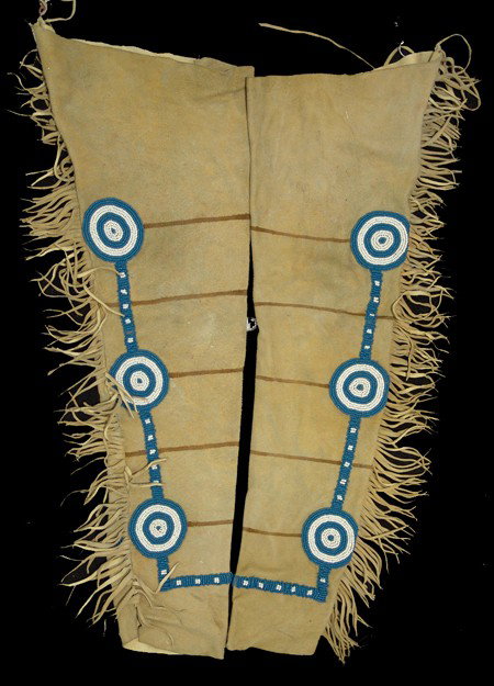 Cheyenne Leggings: Circa Mid 1900s, Traditional pair of buckskin leggings with pony beaded rosettes and painted/ochred warrior's stripes. Very good condition. 34" x 11" each