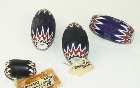 4 Chevron Tradebeads: Collection of 3 blue oval and oblong 6-layer beads plus an older and rarer black barrel shaped 5-layer version. All in very good condition. 2" x 1-1/4" Various