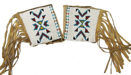 Cheyenne Beaded Cuffs: Traditional pair of well used lazy stitch beaded cuffs with geometric motif. Done on hide and cloth with buckskin fringe and lined with heavy paper where you can see an old cake recipe printed. 7" x 6