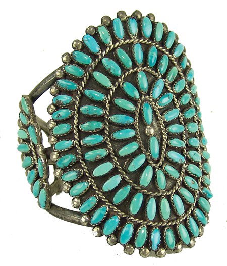 Zuni Bracelet: Circa 1970s, Very fine cluster design all silver cuff bracelet the large rosette and side segments set with 106 matching turquoise stones with beautiful natural aging. Very good condition. 5" x 3-1/8"