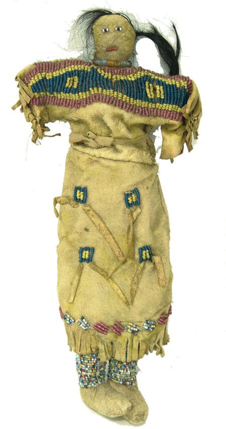 Plains Buckskin Doll: Circa Early 1900s, Beautiful sinew sewn and lazy stitch beaded doll with three-color yoke on the dress, plus moccasins, fringe, and human hair. 13" long