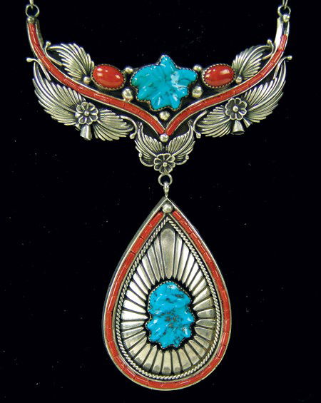 Navajo Necklace: Circa Late 1900s, Unique original design two-piece sterling necklace with carved turquoise stones, finely inlaid bands of coral, and fine leaf work. Very good condition, retail- $3,000. 3" x 2" pendan