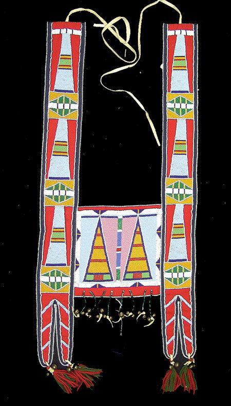 Crow Martingale: Circa 1980s, Beautiful red and blue tradecloth horse collar with traditional flat beaded Crow designs on strap and front panel, small brass bells, and wool tufts. Excellent condition. (Matches lots #6