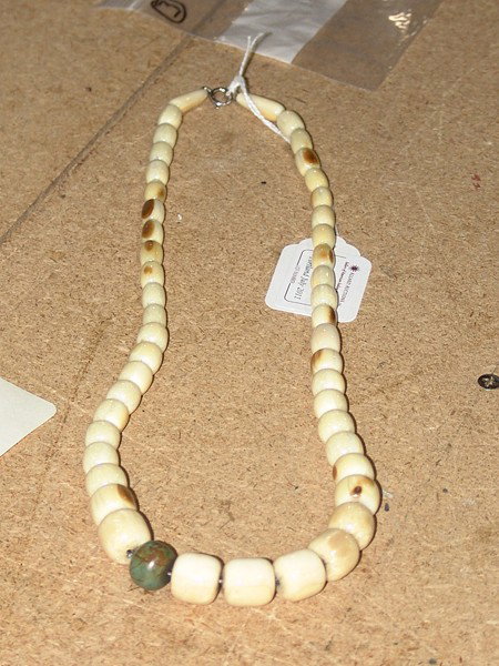 Fossilized Mastadon Tusk Necklace: Beautiful graduated strand of hand honed fossilized mastadon tusk beads with jasper bead in middle. Size: 24"