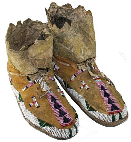 Sioux Child's Moccasins: Early 1900s, Classic pair of sinew sewn and lazy stitch beaded buckskin moccasins with rawhide soles and some yellow ochreing. Very good condition. 7-1/2"