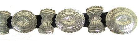 Navajo Concho Belt - Dennis James: 1970s, Beautiful all-silver concho belt with sixteen hand stamped repousse' conchos and buckle. Very good condition. 40-42" waist, 2-1/2" conchos From the Janulewicz collection.