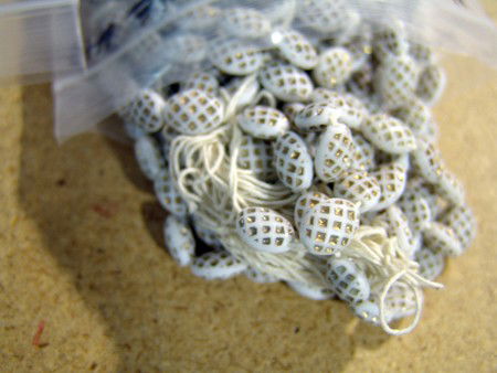 Tradebeads: Early 1900s, Large bag of antique milk glass trade beads with gold pattern. Very good condition.
