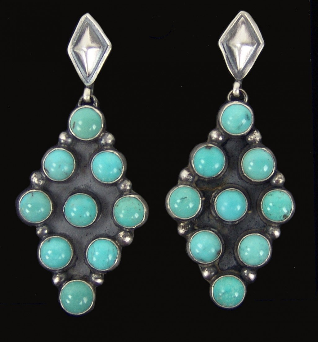 Navajo Earrings- Rita James: Beautiful pair of silver post earrings with diamond shaped suspensions each containing nine turquoise stones. Very good condition. Circa: 1980s Size: 2" x 1"