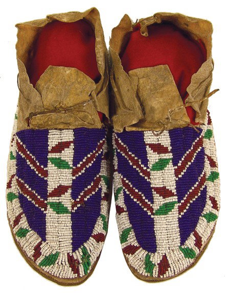 Cheyenne Beaded Moccasins: Early 1900s, Beautiful pair of sinew sewn and lazy stitch beaded buckskin moccasins buffalo rawhide soles and interesting chevron design. Very good condition, few missing beads. 10"
