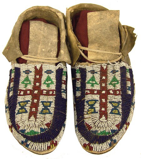 Cheyenne Beaded Moccasins: Early 1900s, Classic pair of sinew sewn and lazy stitch beaded moccasins with hard buffalo soles and beautiful and interesting designs (including some whiteheart beads.) 10"