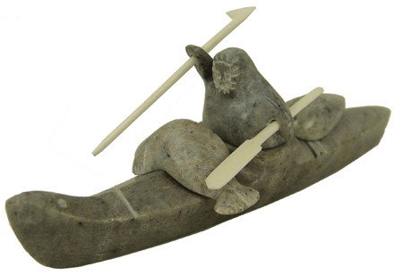 Eskimo Soapstone Sculpture- Ben Saclomona: 1970s, Fine carving of a seal hunter with his catch holding a harpoon and paddle in his kayak. Very good condition. 1-1/4" x 6" x 2"