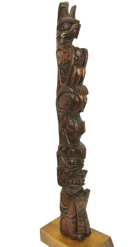 Northwest Coast Model Totem Pole: Mid 1900s, Large well carved alderwood pole with elaborate figures including a bear holding a Northwest Coast "copper." Very good condition, dark stained finish, nice patina. 31" x 3-1/2" x 3-1/2" + b