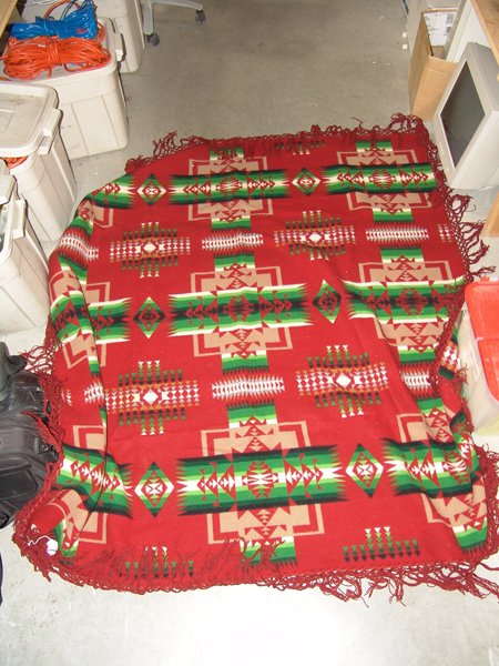 Pendleton Woolen Blanket: Traditional finely woven all wool burgundy "shawl" with original tag and hand tied fringe. Good condition but one small hole in body. Circa: 1980s Size: 68" x 65"